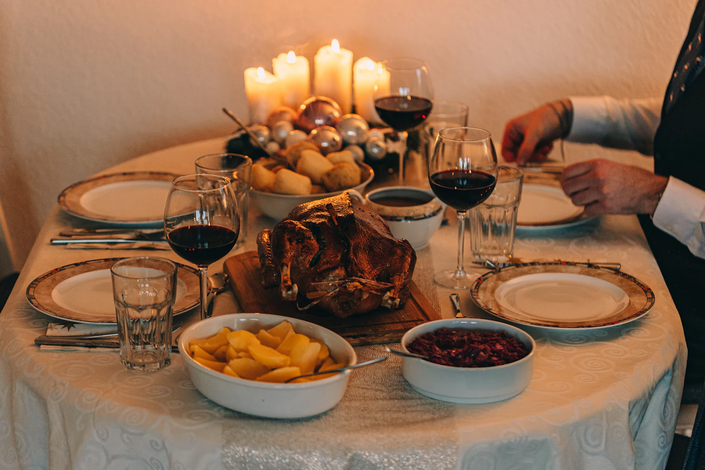 Feestelijk gedekte tafel met rode wijn en kaarsen